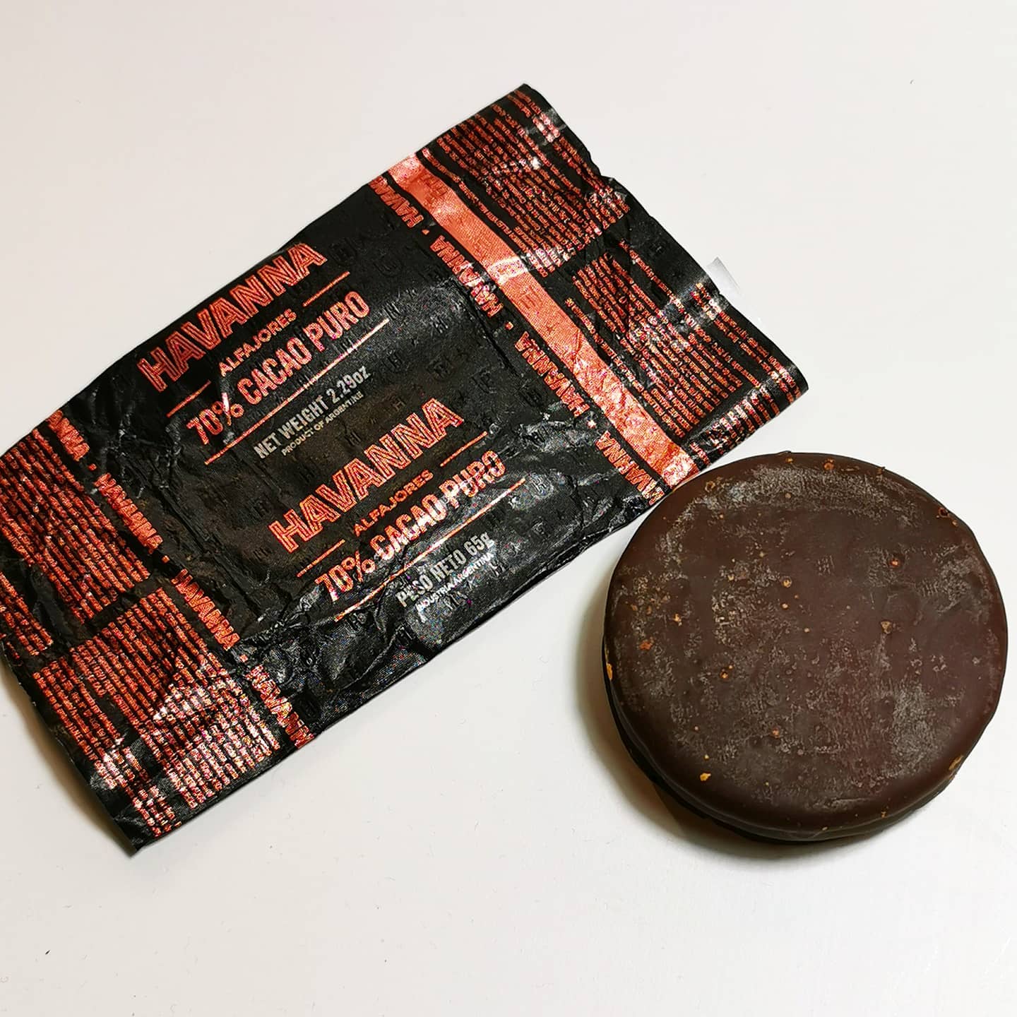 The Havanna Alfajor.This little piece was anonymously delivered to me all the way from Argentina before the lockdown and I have no idea what it is.Up until now I had never heard of Havanna, but turns out it is actually a pretty big deal in the food production world. Based in Argentina, one of it’s more famous products is Alfajores. I had never heard of Alfajores either, and it turns out this is a big deal too. Oh what a life I have led, sheltered from the foodstuffs of the Latin Americas and parts of Europe.This luxurious chunk of what I hope is chocolate is strictly controlled and in Spain, at least, the Ministry of Agriculture and Fisheries has given the following strict guidelines as to what can be called an Alfajor:.“... según el reglamento, se emplearán exclusivamente miel pura de abeja, avellanas, almendras, pan rallado, harina, azúcar y especias (matalauva, cilantro, ajonjolí, clavo y canela). Los alfajores tendrán forma cilíndrica, con un peso mínimo de 30 gramos por unidad, con un tamaño mínimo de siete centímetros de longitud y un diámetro mínimo de 1,5  centímetros.”.¿en inglés?Oh sorry!.... according to the regulation, pure bee honey, hazelnuts, almonds, breadcrumbs, flour, sugar and spices (matalauva, coriander, sesame, cloves and cinnamon) will be used exclusively. The alfajores will have a cylindrical shape, with a minimum weight of 30 grams per unit, with a minimum size of seven centimeters in length and a minimum diameter of 1.5 centimeters.Additionally it has to be packaged individually in wax paper or similar before being boxed in ONLY cardboard or wooden boxes. Never plastic.Damn they ain’t messing about with this shit..Biting into this thing was pure pleasure. The 70% cacao chocolate did it’s job offsetting the sweetness with bitterness, really damn delicious and the caramel was a nice little punctuation, but the main feature of this shit for me was the texture. It was soft, smooth and crumbly, a little chewy, kind of like cookie dough or a well made brownie. I am actually a bit lost for words at how good this was. If you get the chance to try one, do so.The Alfajor and Omegajor - 9/10#alfajores #cookie #biscuit